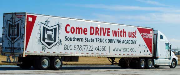 A semi truck with a sign that says come drive with us.